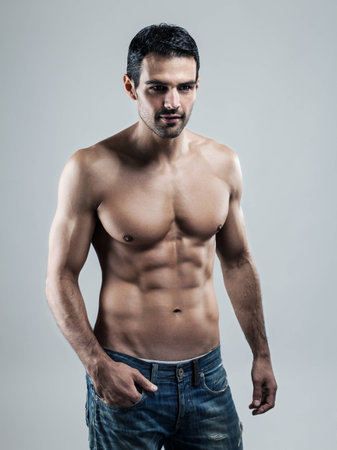 A handsome muscular man posing at a studio の写真素材