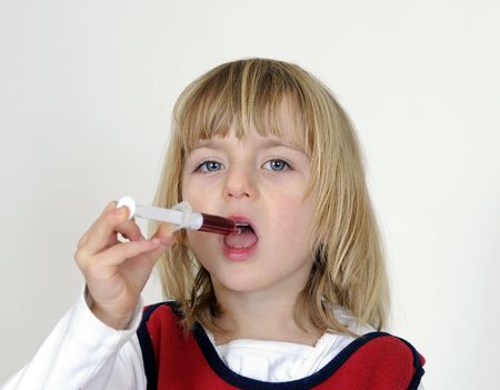 blond little girl takes medicine with injectionの写真素材