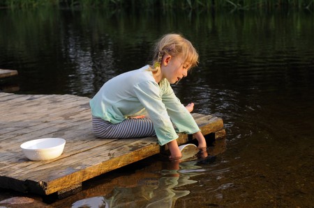 little girl on the river washes upの写真素材