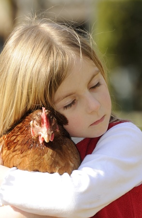 little girl hugging a chickenの写真素材