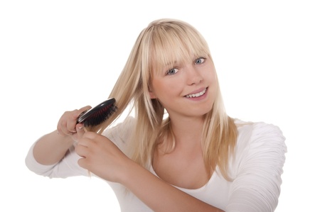 young blond woman combing her hairの写真素材