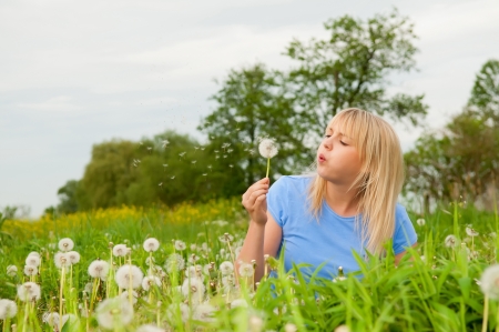 beautiful young blond woman with dandelionの写真素材
