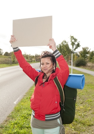 Hitchhiker with blank sign on the roadsideの写真素材