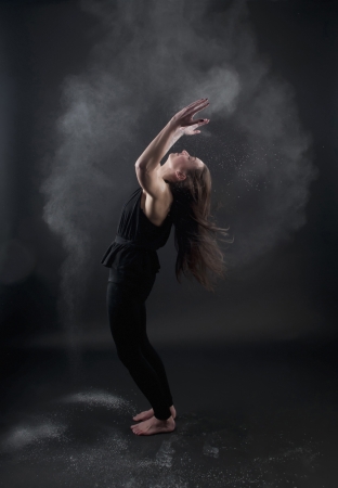 young woman cheering, dark backgroundの写真素材