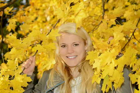 beautiful young blond woman  in autumn parkの写真素材