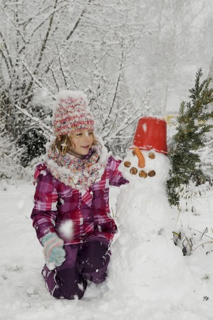 laughing little girl with snowmanの写真素材