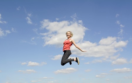 joyful young blond woman leaping