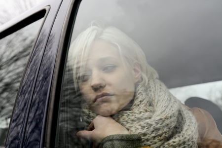 thoughtful young woman in the car