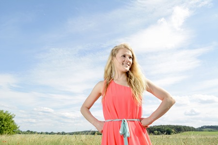  happy young blond woman against blue skyの写真素材