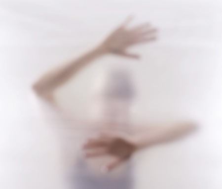 afraid young woman behind foilの写真素材