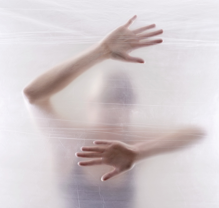 afraid young woman behind foilの写真素材