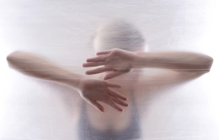 afraid young woman behind foilの写真素材