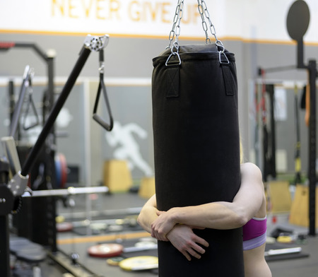 exhausted young woman on punchbagの写真素材