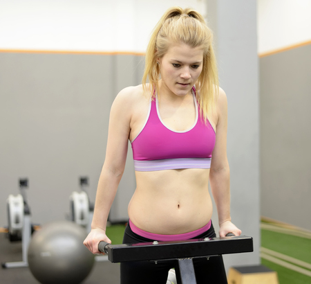 Young blond woman exercising in gym