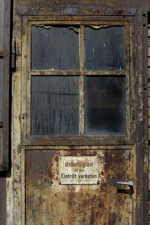 Old rusty door with warning signの写真素材