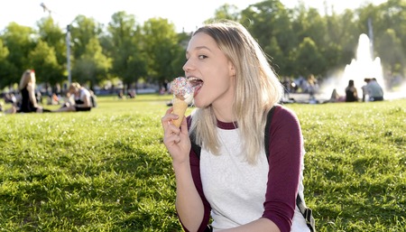 happy young woman eating ice creamの写真素材