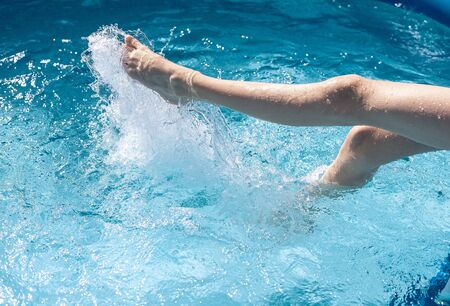 feet splashing in the swimming pool