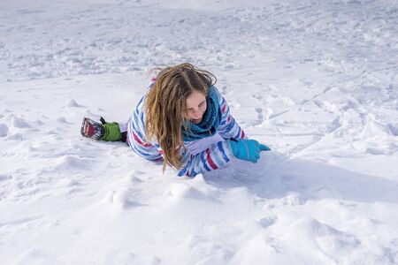 young girl falling in snowの写真素材