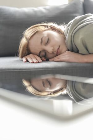 sleeping young woman with digital tabletの写真素材