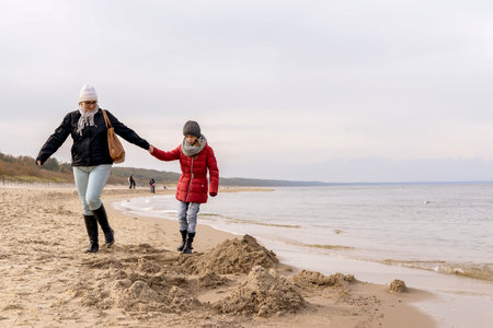 mother and daughter walking on the beachの写真素材