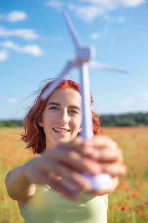 girl with wind turbine in poppy fieldの写真素材