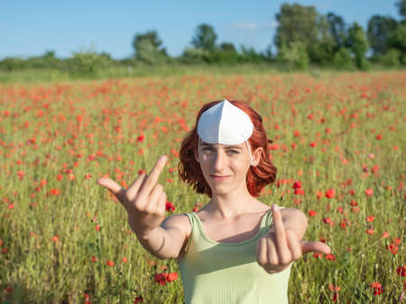 frustrated young girl with protective mask in poppy fieldの写真素材