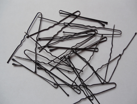 Many black pins and hair clips on white backgroundの写真素材