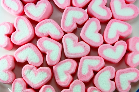 sweet hearts shaped marshmallows on pink background