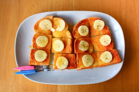 bread toast with honey and banana on plateの写真素材