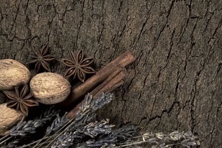 Sicks walnuts cinnamon star anise and dry lavender on cork boardの写真素材