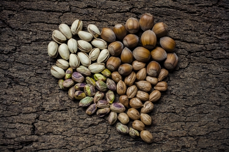 Heart - shaped nuts: hazelnuts and pistachiosの写真素材