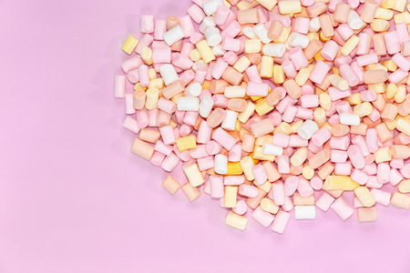 Top view on multi-colored marshmallows on a monochrome pink background.の写真素材