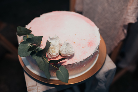 Beautiful wedding cake decorated with fresh flowers and leaves.の写真素材