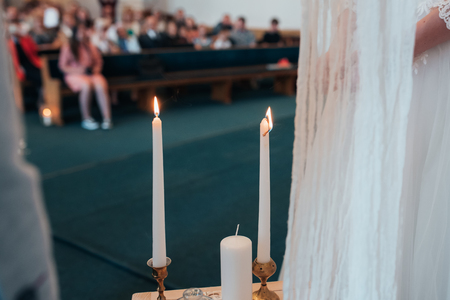Small wedding table in white with candles and flowers.の写真素材