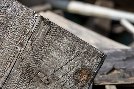 A stack of old wooden planks that lie on the ground.