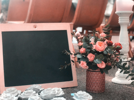 A bouquet in a rustic style with a frame and a black board for drawing a place for textの写真素材