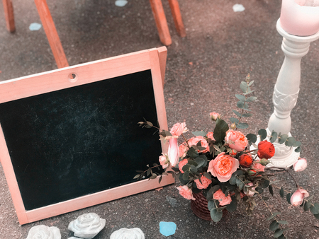 A bouquet in a rustic style with a frame and a black board for drawing a place for textの写真素材