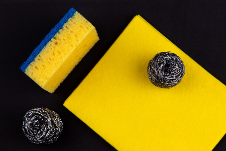 Dishwashing concept. On a black background, different washcloths and scrubbers for washing dishes.の写真素材