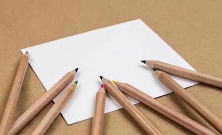 notebook blank page colorful pencil mock-up composition. Back to school concept with stationery office supplies on a brown craft paper background copy space.の写真素材