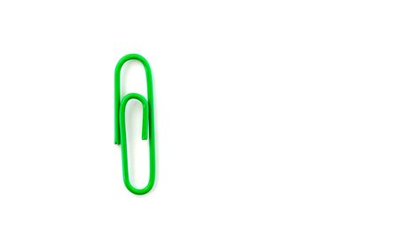 Green paper clip isolated on white background. Close up and top viewの写真素材