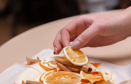 Women's hand making decorations from dried oranges, stars from tangerine and cinnamon. Girls party or meeting.の写真素材