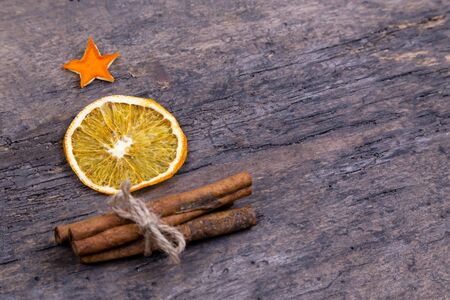 A pile of cinnamon sticks, dried orange and tangerine stars on old wooden table in the form of a Christmas tree with copy space. Christmas decoration. Christmas card.の写真素材