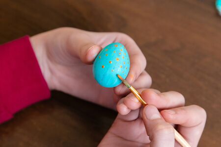 easter, holidays, tradition and people concept - close up of woman hands coloring easter Quail eggs...
