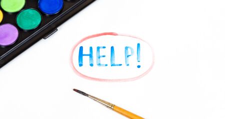 Handwritten HELP text with brush and watercolor paints on white background. Handwritten colors...