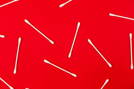 Flat lay composition with cotton swabs on red background. Top view ear sticks.の写真素材