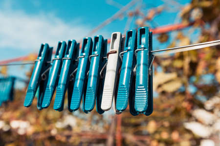 Outdoor clothesline with hanging clothespins. Concept of housework, chores, laundry and energy cost...