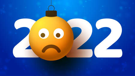 Greeting card for 2022 new year with sad emoji face that hangs on thread like a christmas toy, ball...