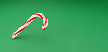 Merry Christmas canes, lollipop mint candy with red stripes on green background. New Years celebration concept. Traditional sweet dessert. 3d renderの写真素材