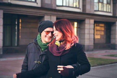 Young happy smiling couple in love have fun outdoor in cold autumn winter weather