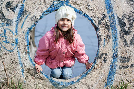Cute little girl playing on outdoor playground equipment